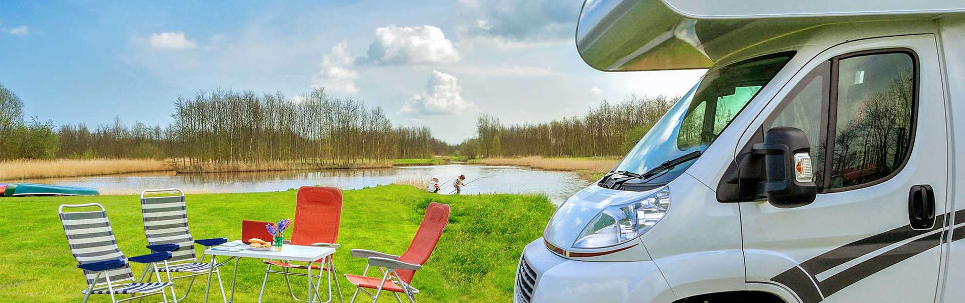 Motorhome with table and chairs in field