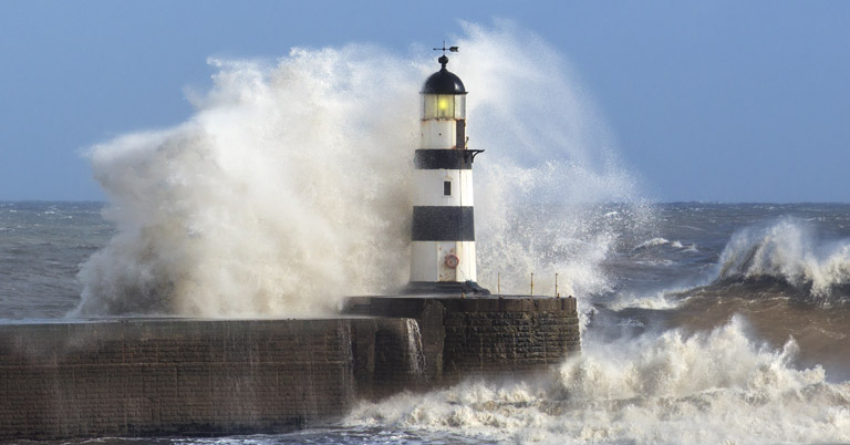 Waves crashing against lighthouse